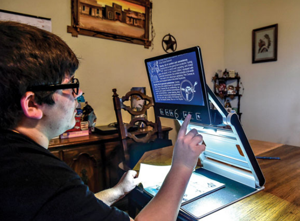 NEW WAY OF READING – Tristan uses a special computer that works like an overhead projector so he can better see his assignments. Messenger Photo by Joe Duty.